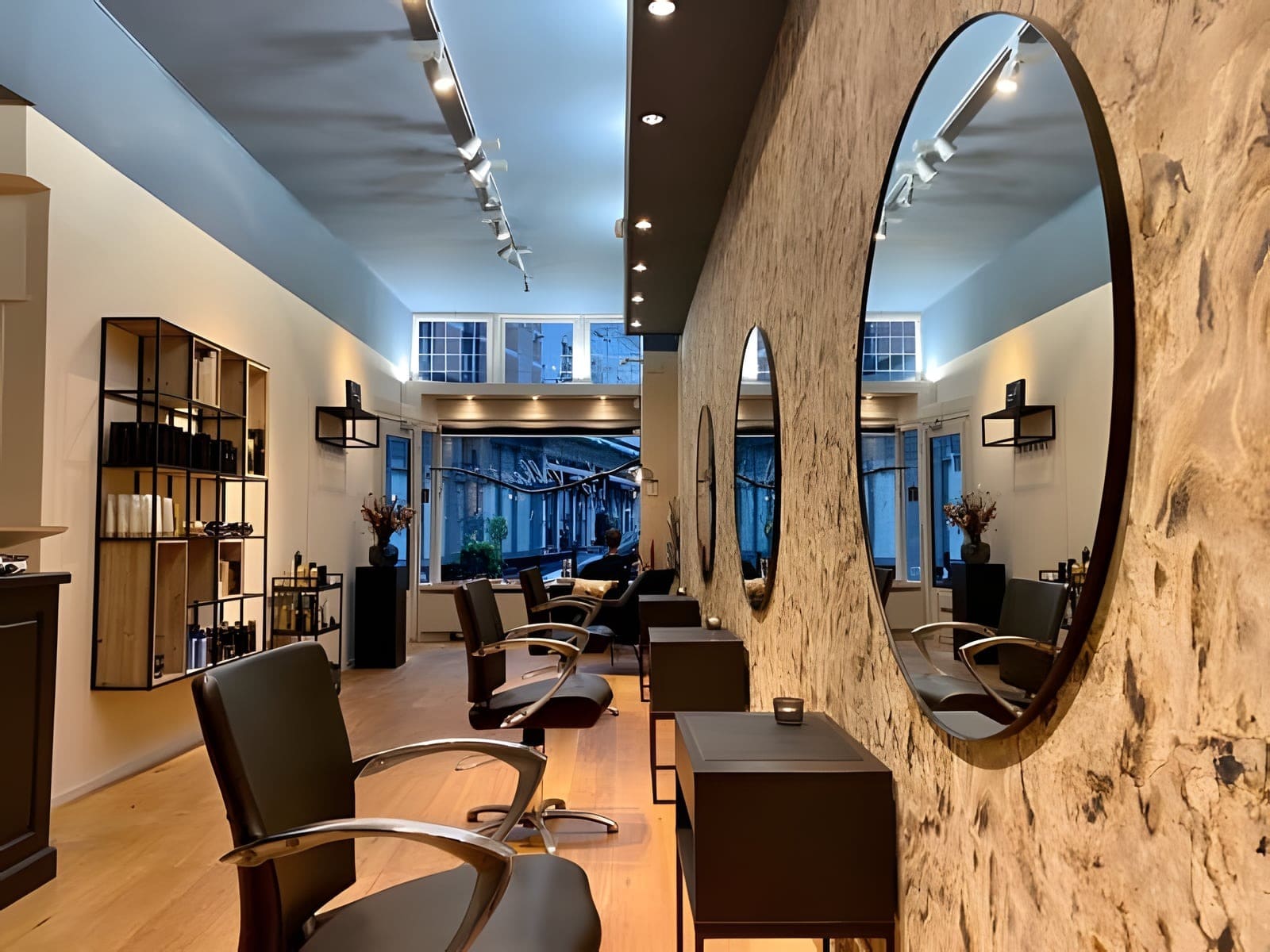 Doorkijk door de salon met ronde spiegels tegen de houten wand en de blauwe plafondlijst