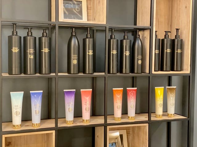 Haarproducten in zwarte flacons en gekleurde tubes op de open stellingwand