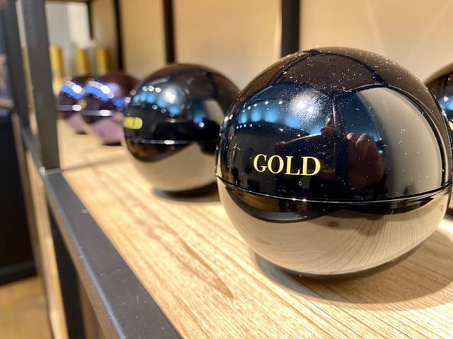 Detail van een glanzende bol met het opschrift Gold op de houten schap