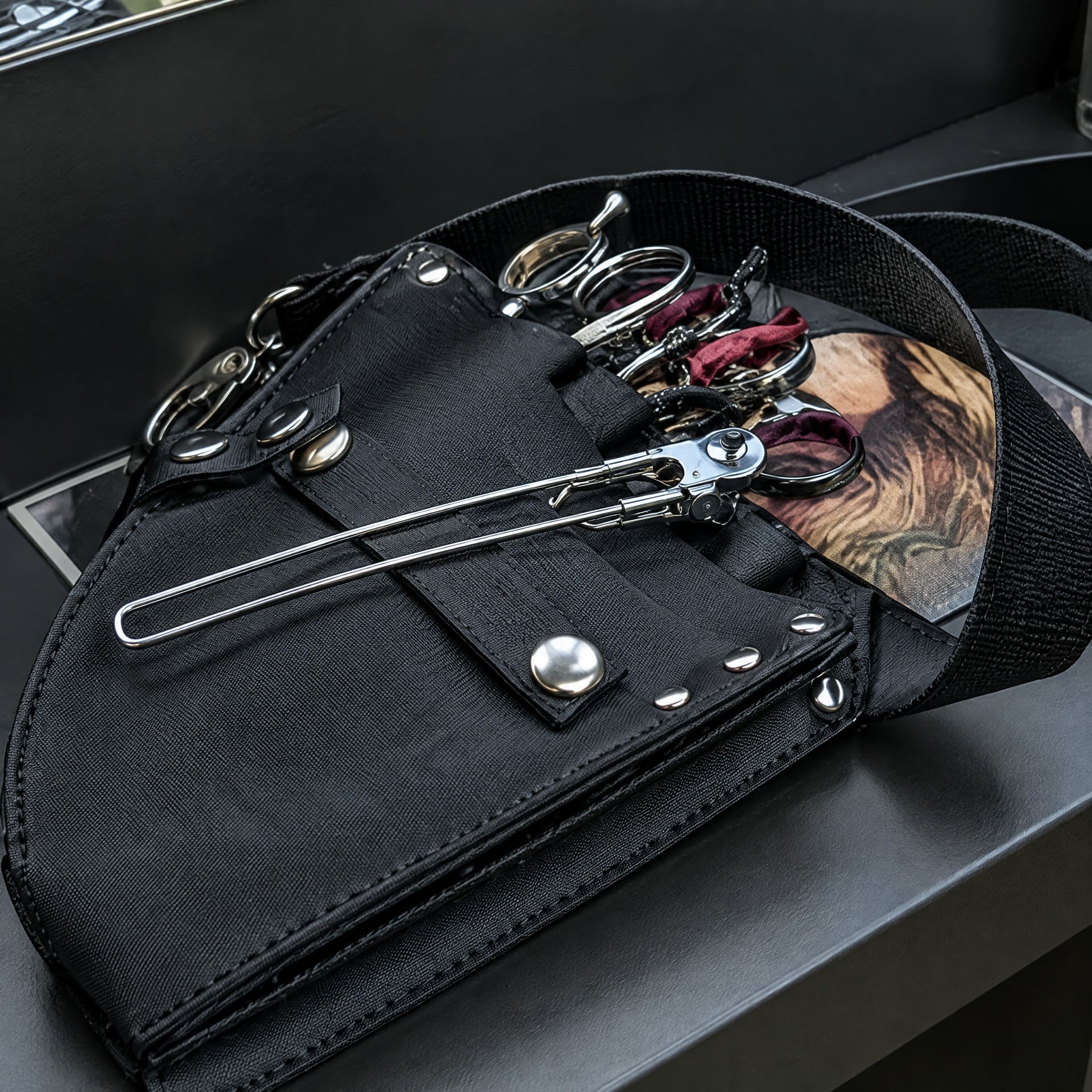 Kappersschaar in een zwarte holster op de werkbank