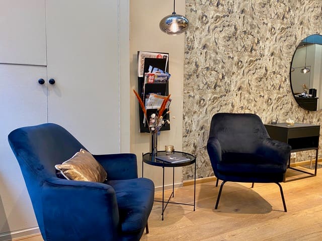 Twee blauwe fauteuils bij de wand met botanisch motief