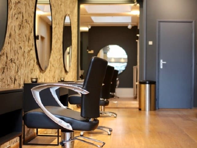 Rij zwarte kappersstoelen voor de ronde spiegels